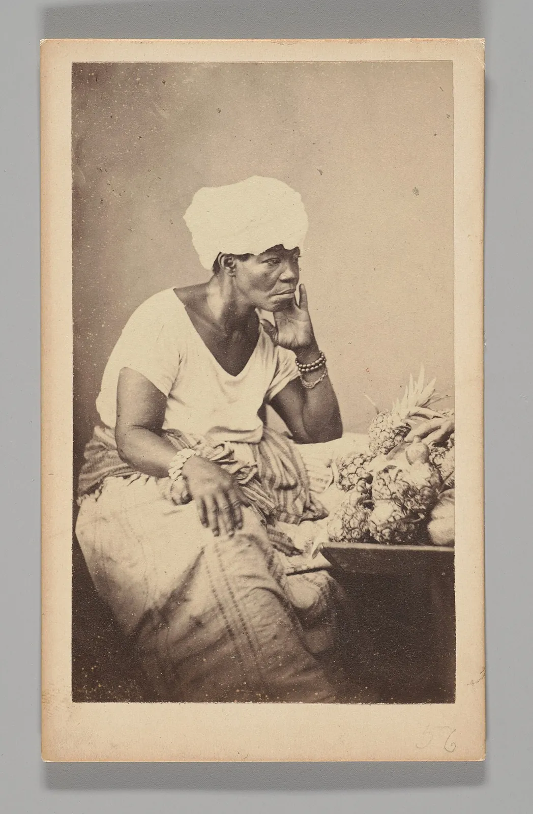 [Studio Portrait: Female Street Vendor Seated Wearing Turban, Brazil] by Georges Leuzinger